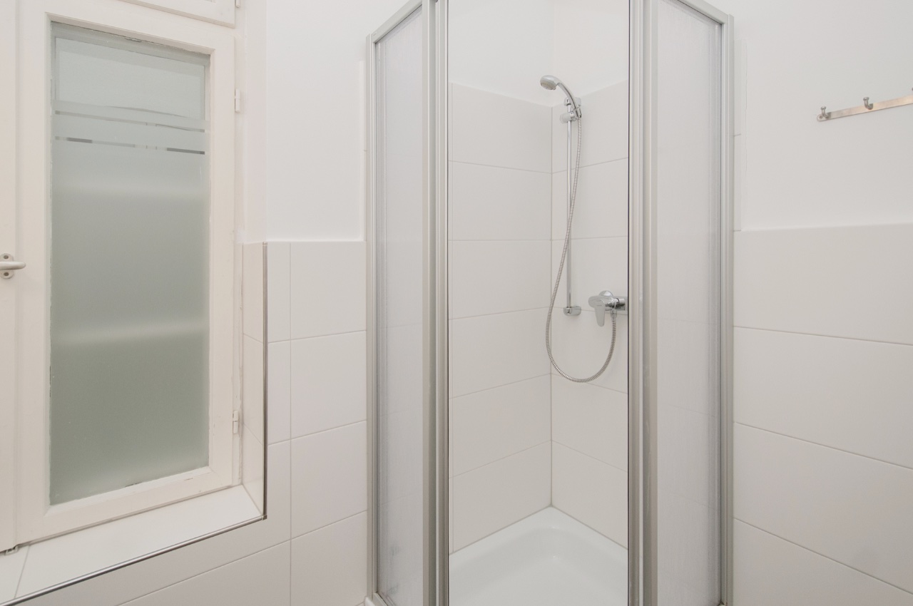 Habitación doble Fleetblick: Baño alicatado en blanco con cabina de ducha esquinera, teleducha y ventana de vidrio esmerilado