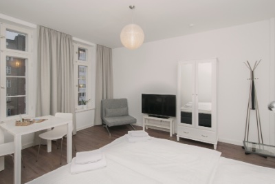 Habitación doble Fleetblick: Habitación clara con cama doble, televisor, armario blanco, sillón, mesa y ventanas con cortinas